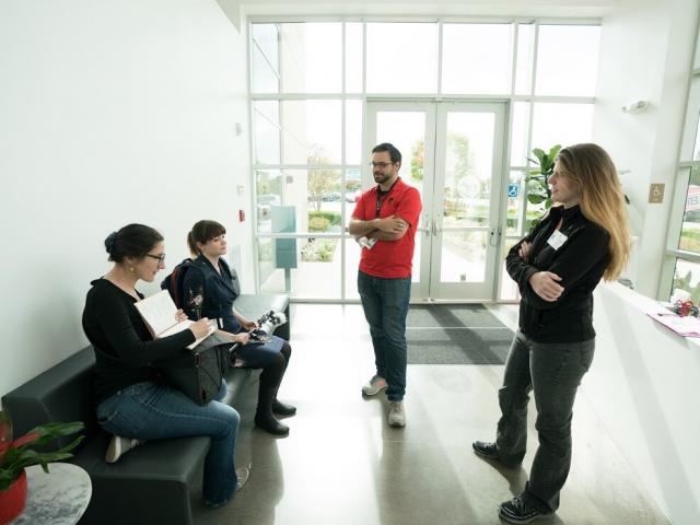McKinnon (left) at Virgin Orbit chatting with scientist, including Susanna Kohler (right), CCS Physics '08
