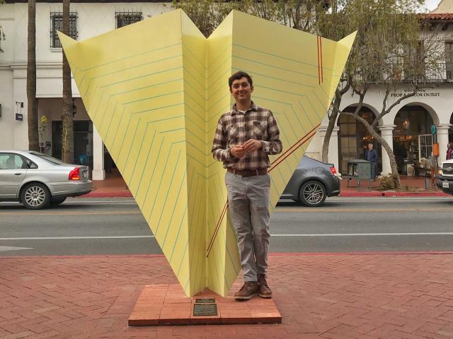 Luis Velazquez in front of "Paper Airplane" on State Street