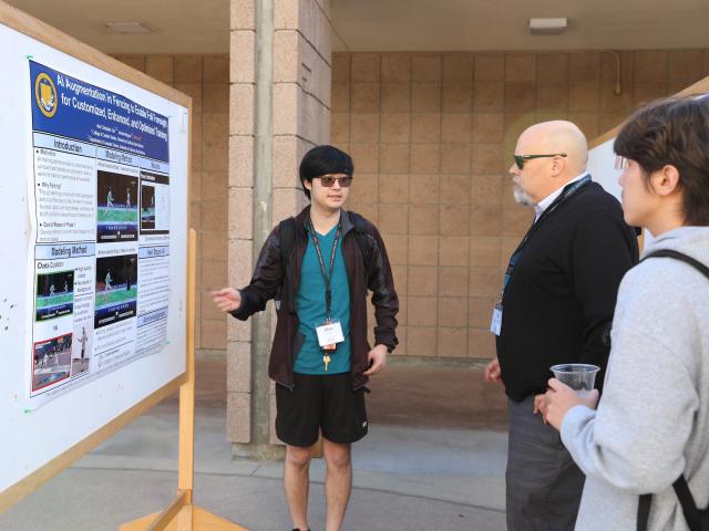 student presents poster to CCS Interim Dean Timothy Sherwood at RACA-CON
