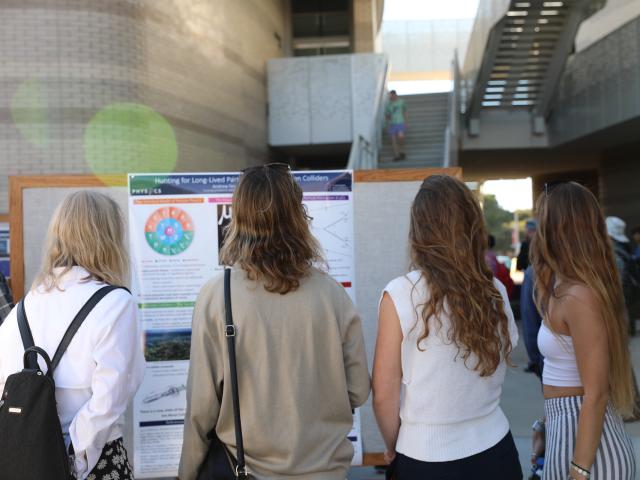 students observing poster at RACA-CON