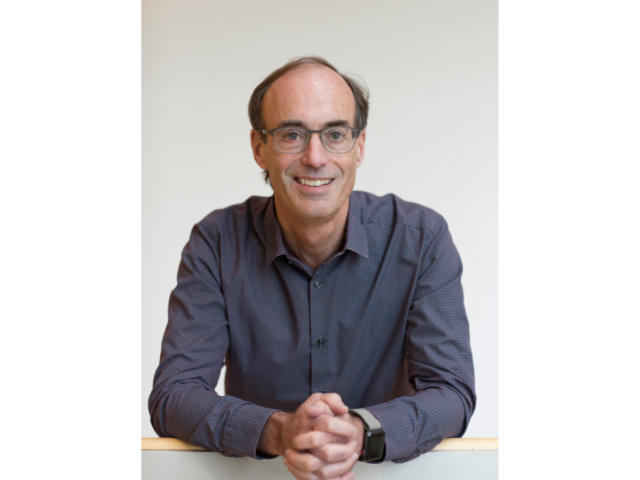 Dr. Ron D. Vale ‘80 (CCS Biology, Chemistry & Biochemistry); alt text: headshot of Ron, a man smiling at the camera wearing a grey button up top and eyeglasses